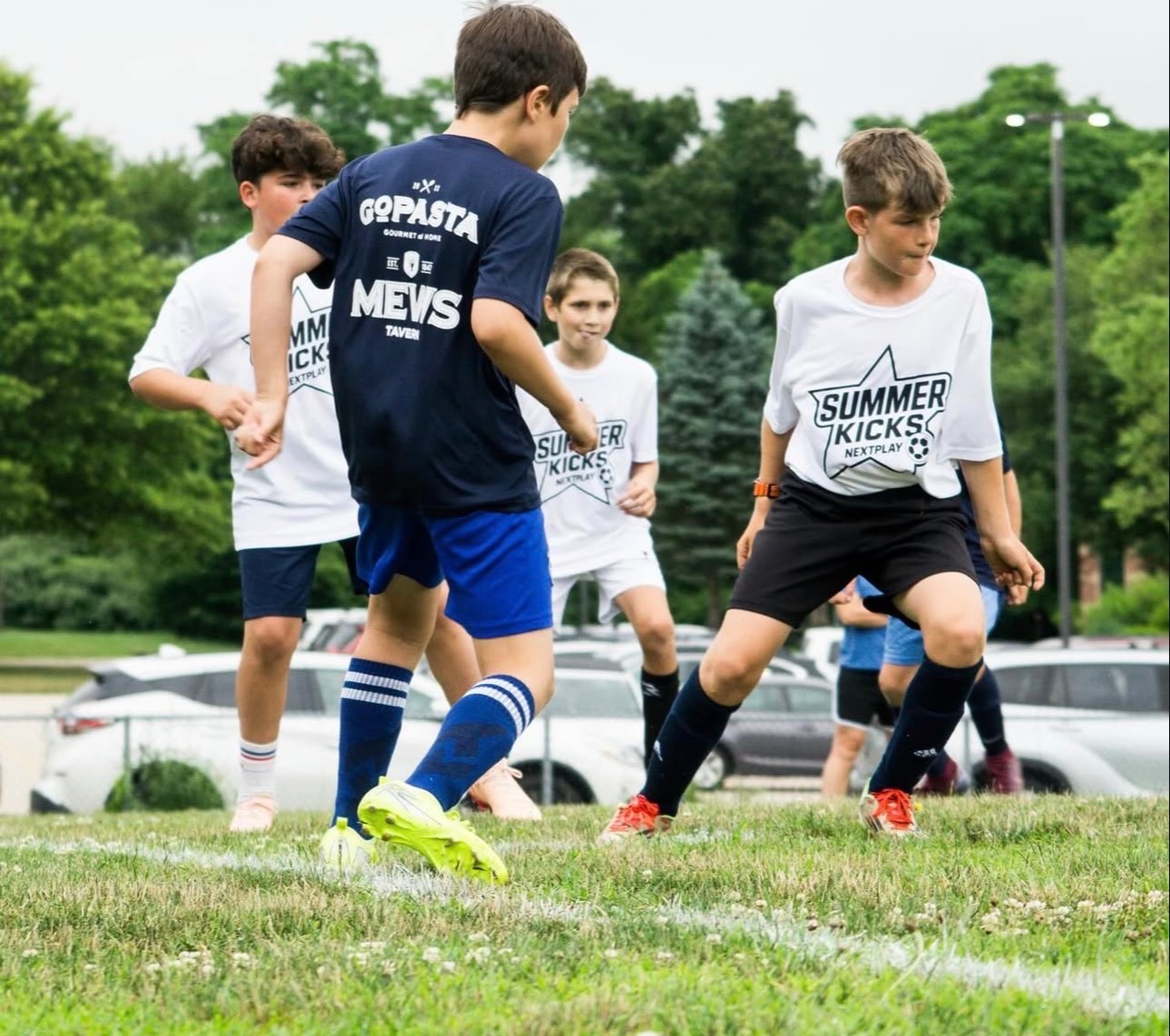 Summer Kicks match play with players competing for the ball